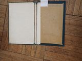 an open book sitting on the floor with a piece of paper sticking out of it