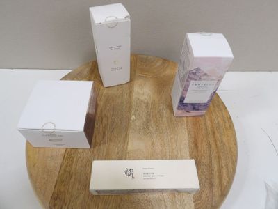 trois boîtes blanches posées sur un plateau en bois, lui-même posé sur une table