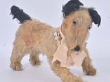 un petit chien brun avec un nœud rose autour du cou