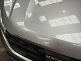 a close up of the hood of a car in a parking lot