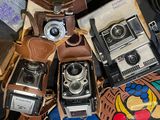 several old cameras are stacked on top of each other on a table