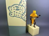 figurine of a man holding a gun in front of a box