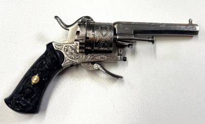 pistolet posé sur une surface blanche, avec une poignée noire et une poignée noire