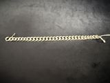 a silver chain bracelet on a black surface