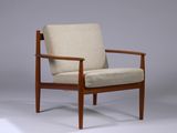 La chaise est en bois et son assise est rembourrée de couleur beige.