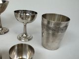 four silver cups and a silver cup on a table