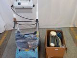 une machine bleue et blanche et une boîte posée par terre
