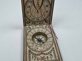 a box with a compass inside of it on a white surface