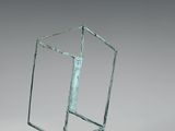 une photo d'une sculpture représentant un cube de verre posé sur un socle métallique
