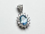 un gros plan sur un pendentif composé d'une topaze bleue et de diamants