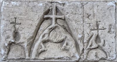 relief of a woman holding a cross and a man holding a candle