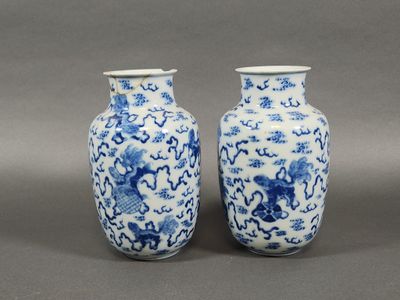 pair of blue and white vases with dragon designs on them