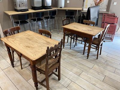 tables and chairs are lined up in a room with a refrigerator