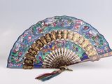 a blue and gold fan that is sitting on a table