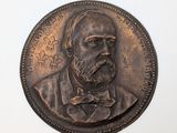 une pièce de bronze sur laquelle figure l'effigie d'un homme