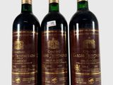 trois bouteilles de vin posées les unes à côté des autres sur une surface blanche