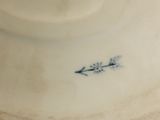 a white plate with a blue flower on it