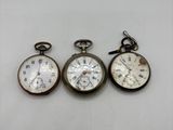trois types de montres de poche sur une surface blanche