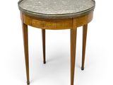 une table ronde avec un plateau en métal et des pieds en bois