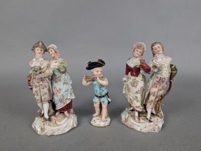 three porcelain figurines of a boy and a girl with a bird