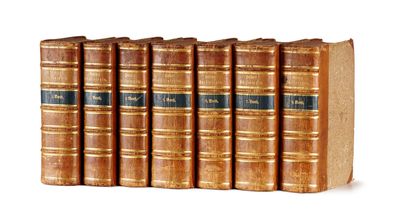 six vieux livres sont alignés sur une surface blanche