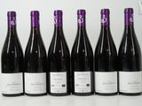 six bottles of wine are lined up on a table