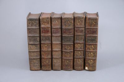 cinq vieux livres alignés sur une surface blanche