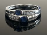 a close up of a ring with sapphires and diamonds