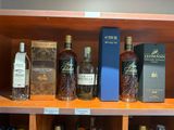 de nombreuses bouteilles d'alcool sur une étagère dans un magasin