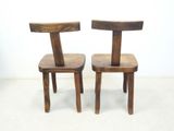 two wooden chairs sitting next to each other on the floor