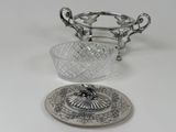 a silver plate with a glass bowl on top of it