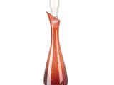 une carafe en verre orange, au col incurvé et au pied blanc
