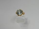 a gold ring with a blue topaz stone in the center