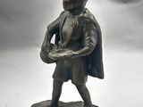 figurine en bronze représentant un homme tenant un plateau de nourriture posé sur un rocher
