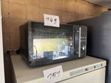 a microwave sitting on top of a refrigerator in a kitchen