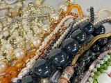 a lot of different colored beads and necklaces on a table