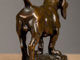 bronze statue of a dog on a base on a table