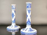 two blue and white candlesticks sitting on a table