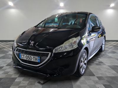 La petite voiture noire est garée dans le garage, sur le sol à damier.