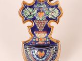 a blue and orange vase with a bird on top of it