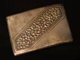 an antique silver cigarette case on a black background