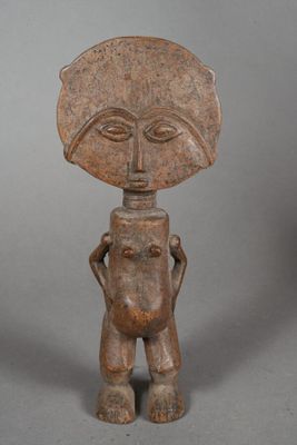 a small wooden statue of a man with a hat on his head