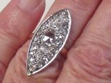 a woman ' s hand holding a ring with a diamond on it