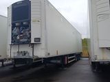 two white semi trucks parked next to each other in a parking lot