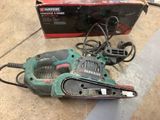a corded sander sitting on the floor next to a box