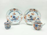 trois pièces de vaisselle en porcelaine bleue, orange et blanche, ainsi qu'une théière