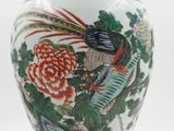 a white vase with a bird and flowers on it