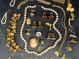 a lot of gold and silver jewelry on a black table