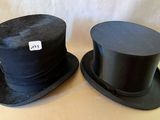 deux chapeaux haut-de-forme noirs posés sur une table
