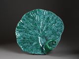 une assiette verte ornée d'un motif en forme de feuille